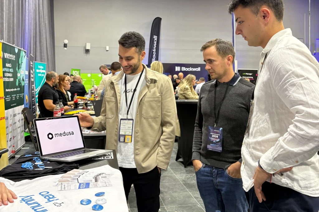 Agilo team demoing the Medusa admin dashboard to visitors at the booth